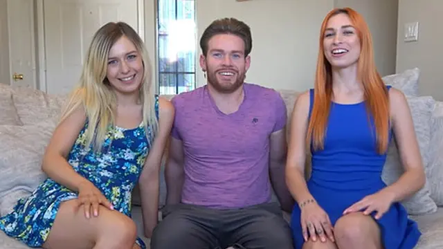 Two girls and a guy enjoy a playful strip darts game together