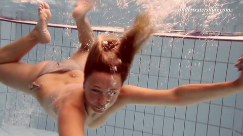 She gets wet beneath the surface, her pert derrière begging for a glimpse inside
